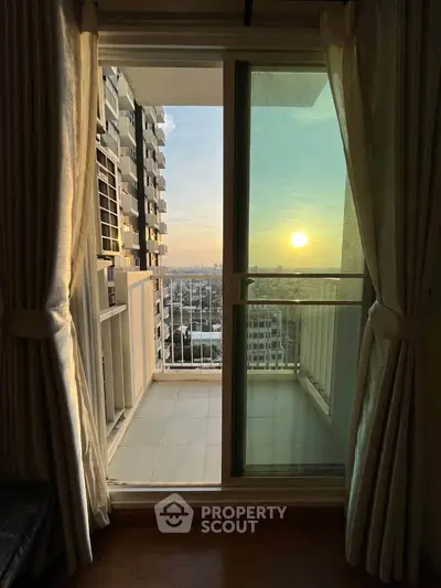 Stunning sunset view from a modern apartment balcony with sliding glass doors.