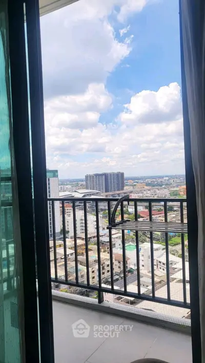 Stunning cityscape view from a high-rise balcony with clear blue skies.
