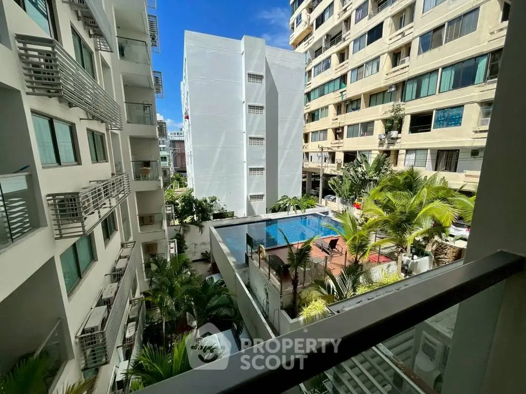Stunning view of modern apartment complex with pool and lush greenery