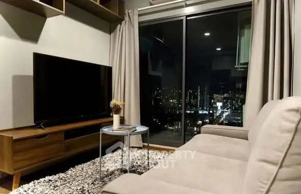 Modern living room with city view, cozy sofa, and large TV, perfect for urban living.