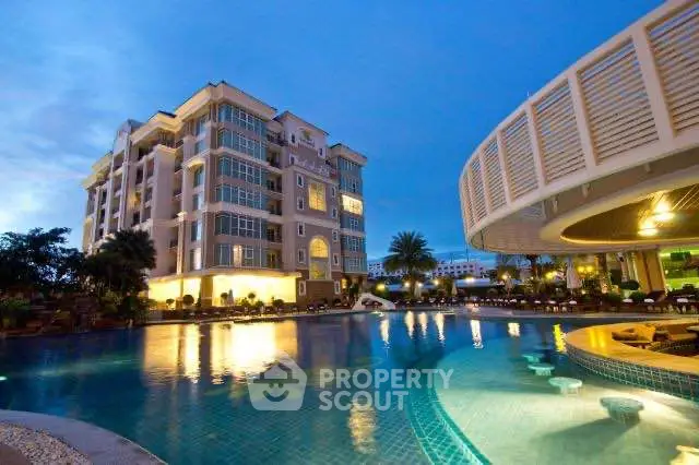 Luxurious apartment building with stunning pool and evening ambiance.