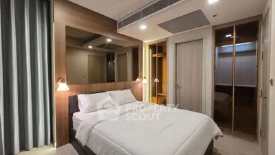 Modern bedroom with elegant design and cozy ambiance, featuring a comfortable bed and stylish lighting.