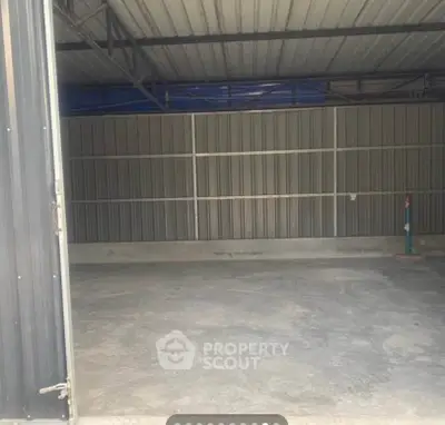 Spacious industrial warehouse with high ceiling and concrete flooring, ideal for storage or manufacturing needs.