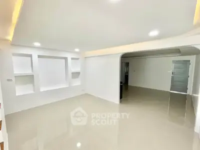 Spacious modern living room with sleek white walls and recessed lighting