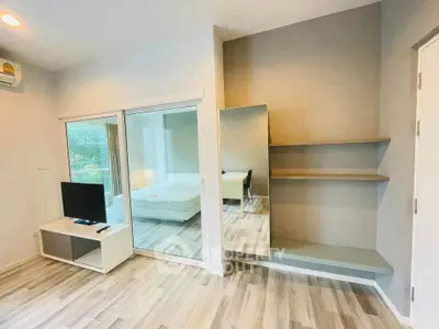Modern living room with sleek design and large mirror, featuring a TV and stylish shelving.