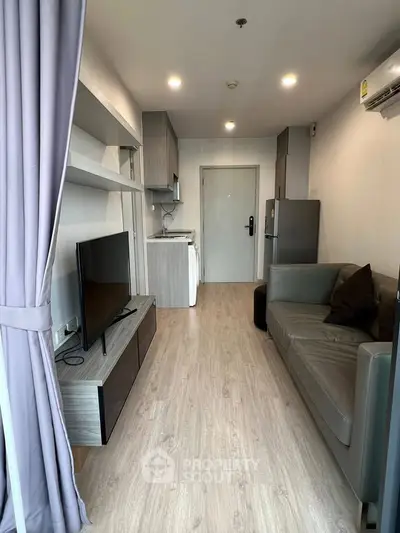 Modern living room with sleek furniture and open kitchen layout in a stylish apartment.
