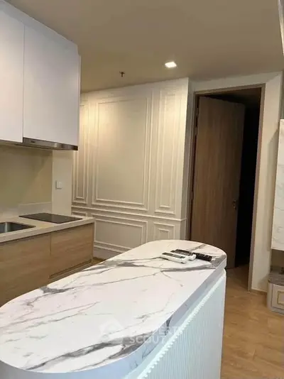 Modern kitchen with marble island and sleek cabinetry in a stylish apartment.