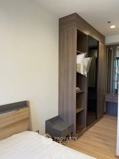 Modern bedroom with stylish wooden wardrobe and cozy bed in a contemporary apartment.