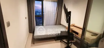 Modern bedroom with city view, featuring a sleek bed and mounted TV for ultimate comfort.