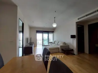 Spacious modern living room with large windows and stylish furniture in a contemporary apartment.