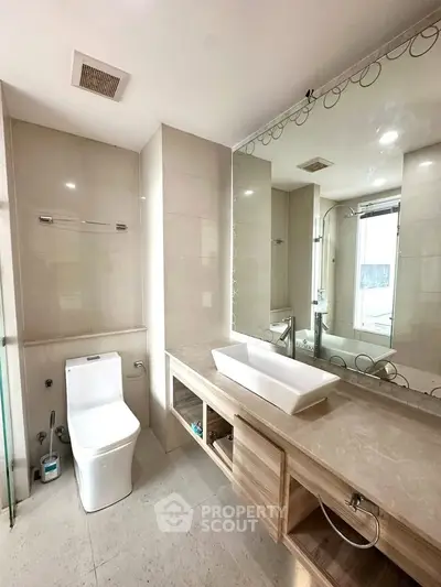 Modern bathroom with elegant fixtures and large mirror in a stylish real estate property.