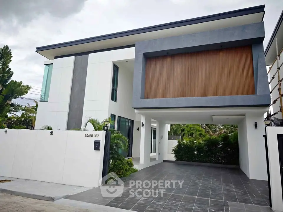 Modern two-story house with sleek design and spacious driveway in a serene neighborhood.