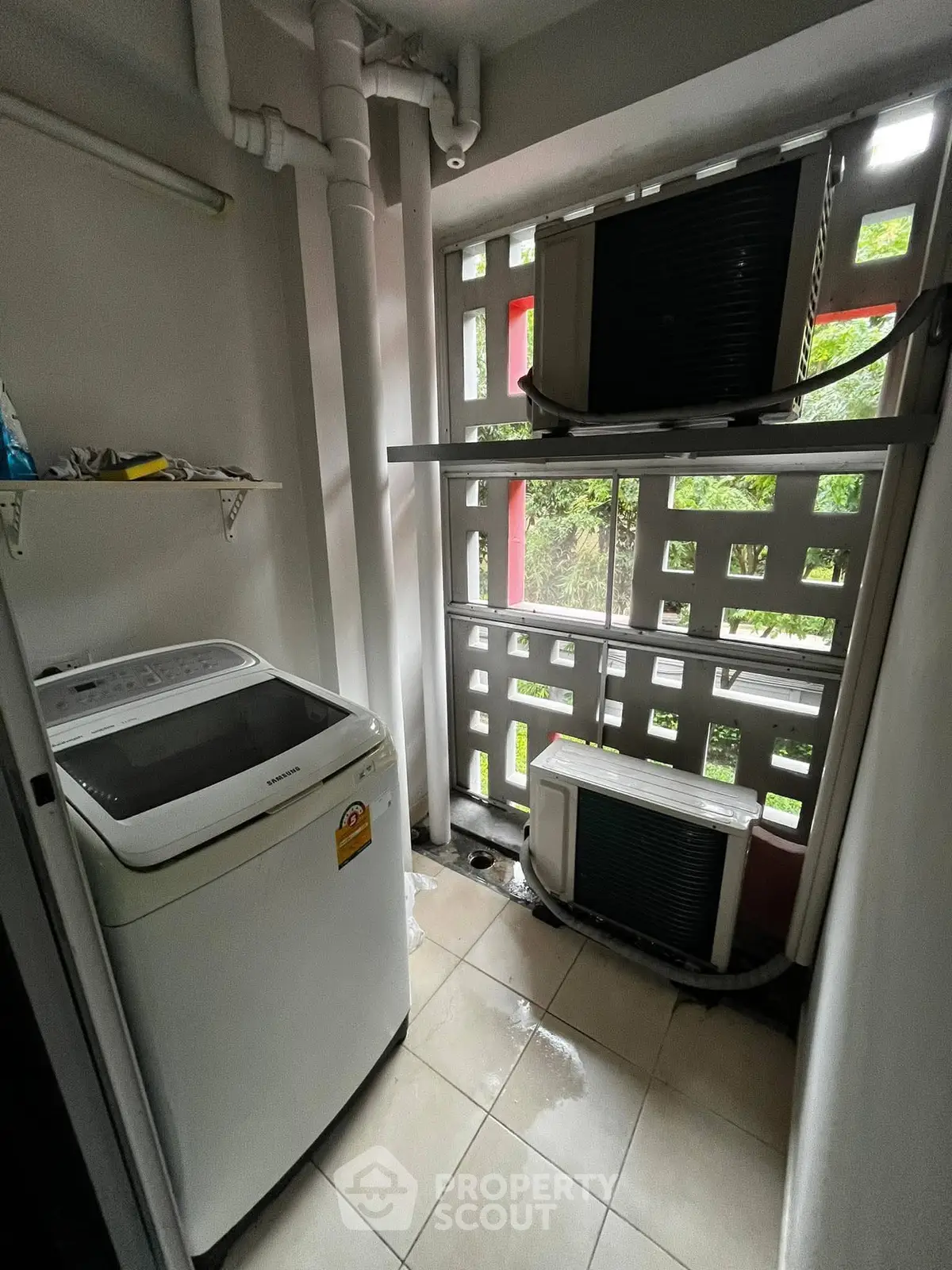 Compact laundry area with washing machine and air conditioning units in modern apartment.