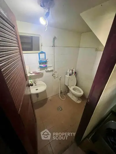 Compact bathroom with essential fixtures and overhead lighting