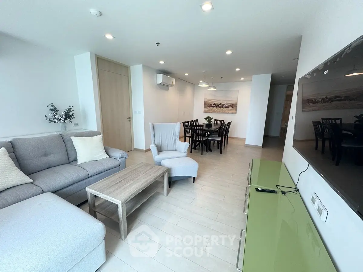 Spacious modern living room with elegant dining area and stylish furniture in a bright apartment.