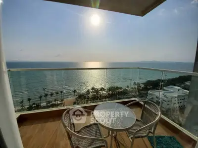 Stunning oceanfront balcony with panoramic sea views and cozy seating area.