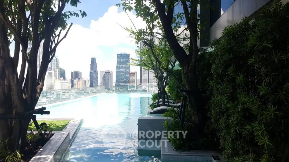 Luxurious rooftop pool with stunning city skyline view and lush greenery.
