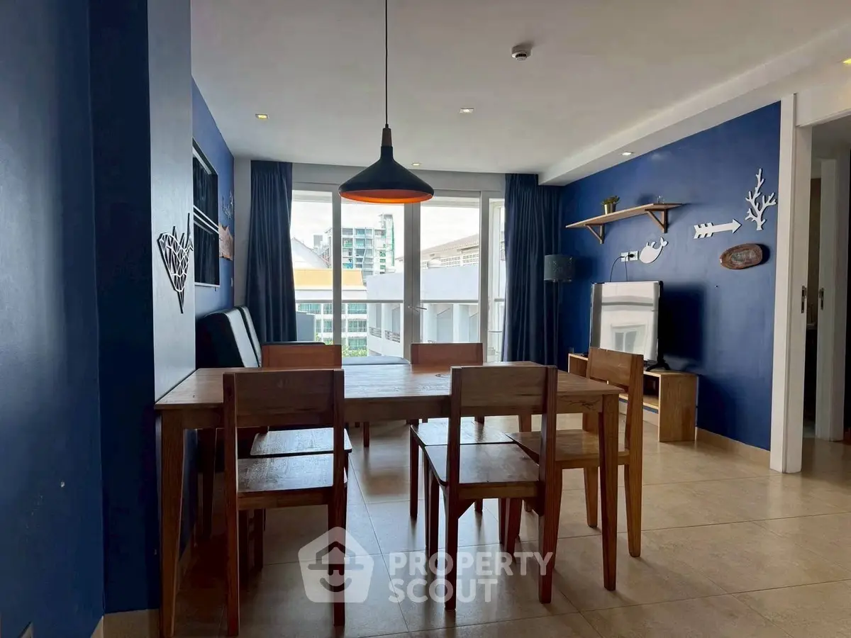 Stylish dining area with wooden furniture and blue accent walls in modern apartment.