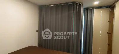 Cozy bedroom with elegant curtains and warm lighting, perfect for restful nights.