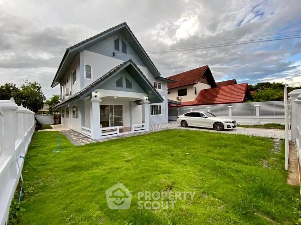 Charming two-story house with lush green lawn and modern car parked in driveway.