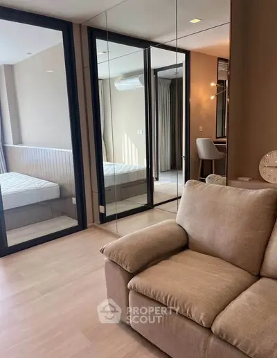 Modern apartment interior with cozy living room and mirrored bedroom doors
