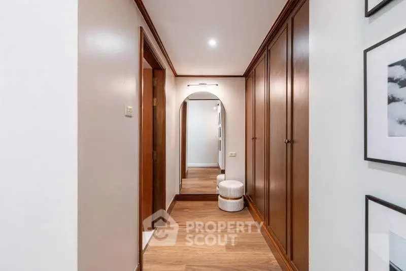 Elegant hallway with wooden flooring and built-in closets in a modern home.