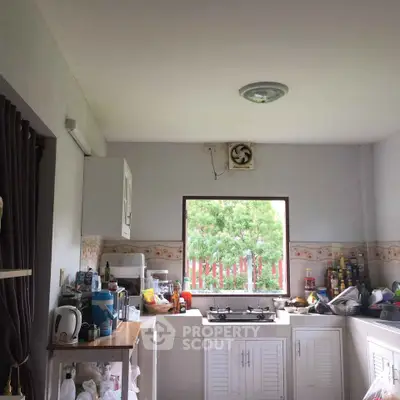 Charming kitchen with gas stove and ample natural light, perfect for culinary enthusiasts.