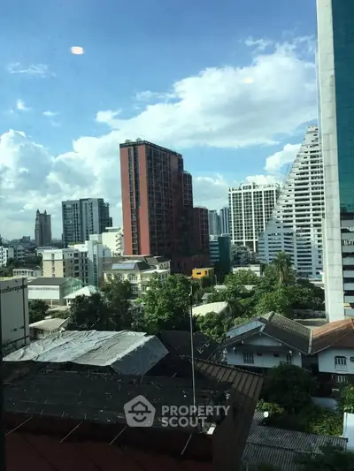 Stunning cityscape view showcasing modern high-rise buildings and lush greenery under a clear blue sky.