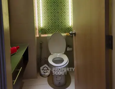 Compact bathroom with modern lighting and patterned wall design