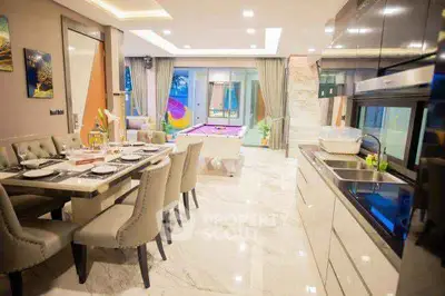 Luxurious open-plan kitchen and dining area with modern decor and pool view.