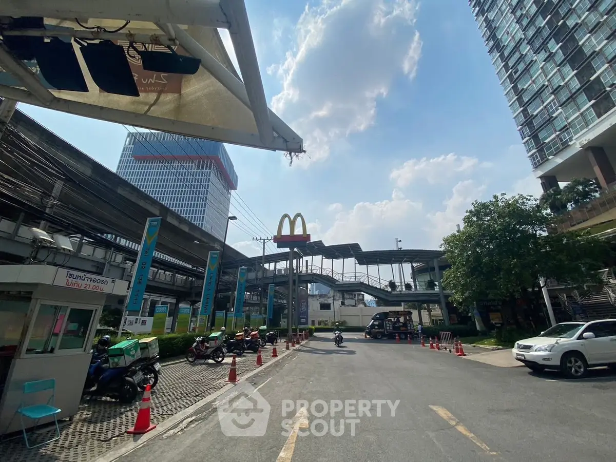 Urban street view with modern buildings and McDonald's sign under a clear blue sky.