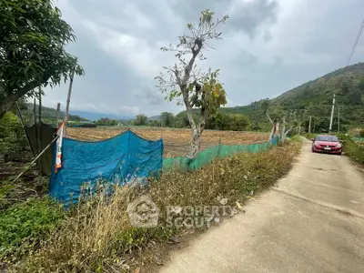 Scenic land plot with mountain views and road access, ideal for development or agriculture.