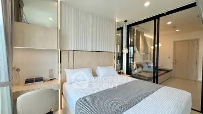 Modern bedroom with stylish decor and natural light, featuring a cozy bed and elegant furnishings.