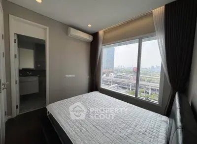 Modern bedroom with large window offering stunning city view