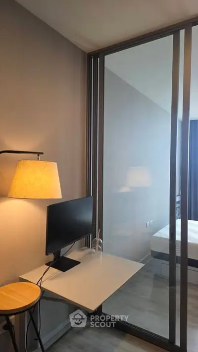 Modern bedroom with glass partition and sleek workspace setup
