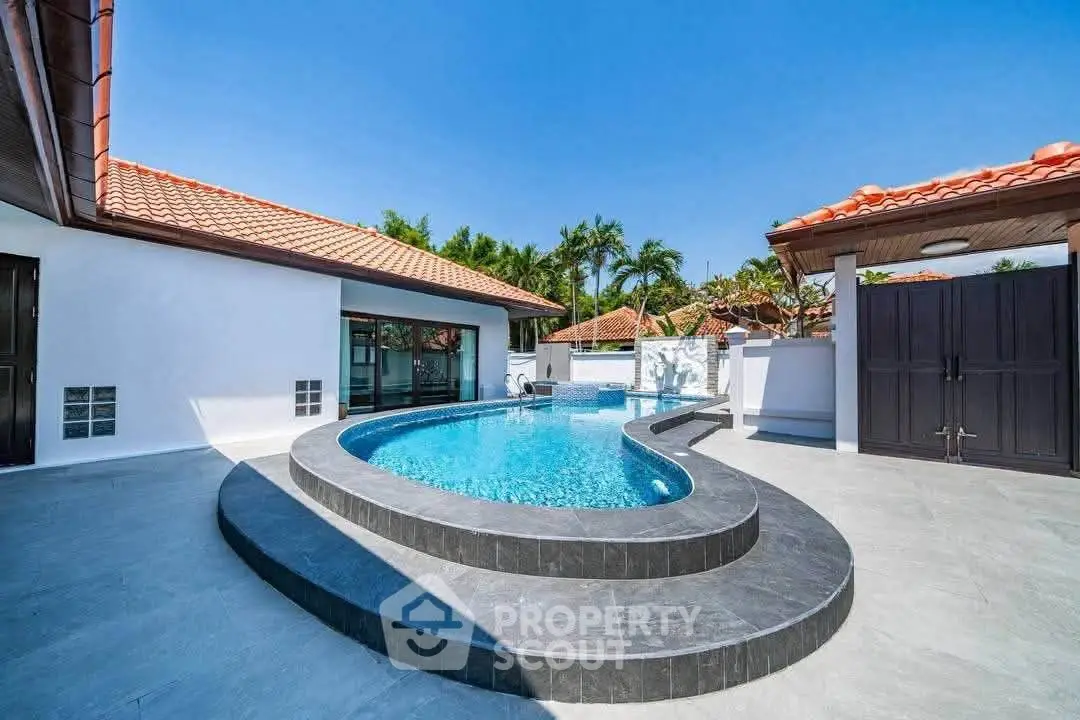 Luxurious villa with stunning private pool and modern architecture under clear blue sky.