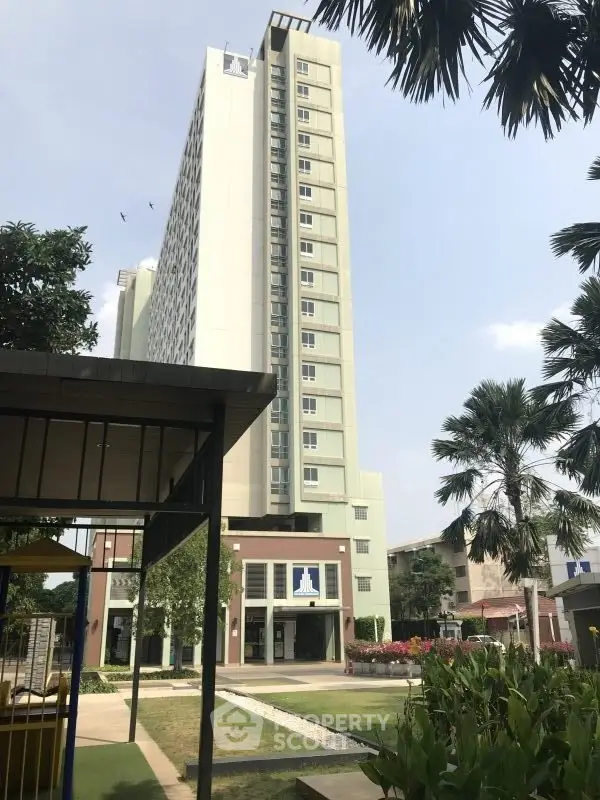 Modern high-rise building with lush garden and clear sky view