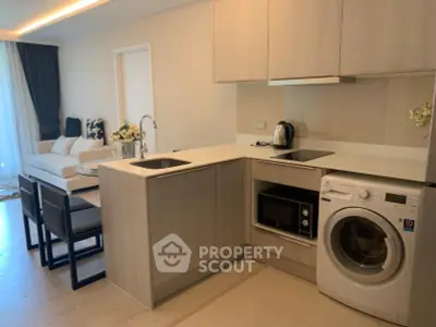 Modern open kitchen with washing machine and cozy living area