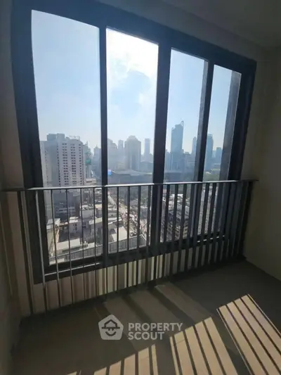 Stunning city view from high-rise balcony with floor-to-ceiling windows.