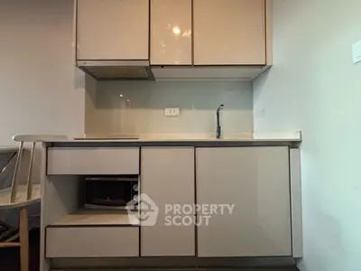 Modern compact kitchen with sleek cabinetry and built-in microwave