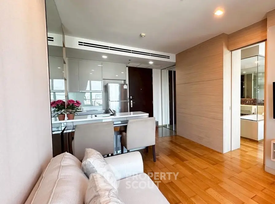 Modern living room with wooden flooring and stylish dining area in a contemporary apartment.