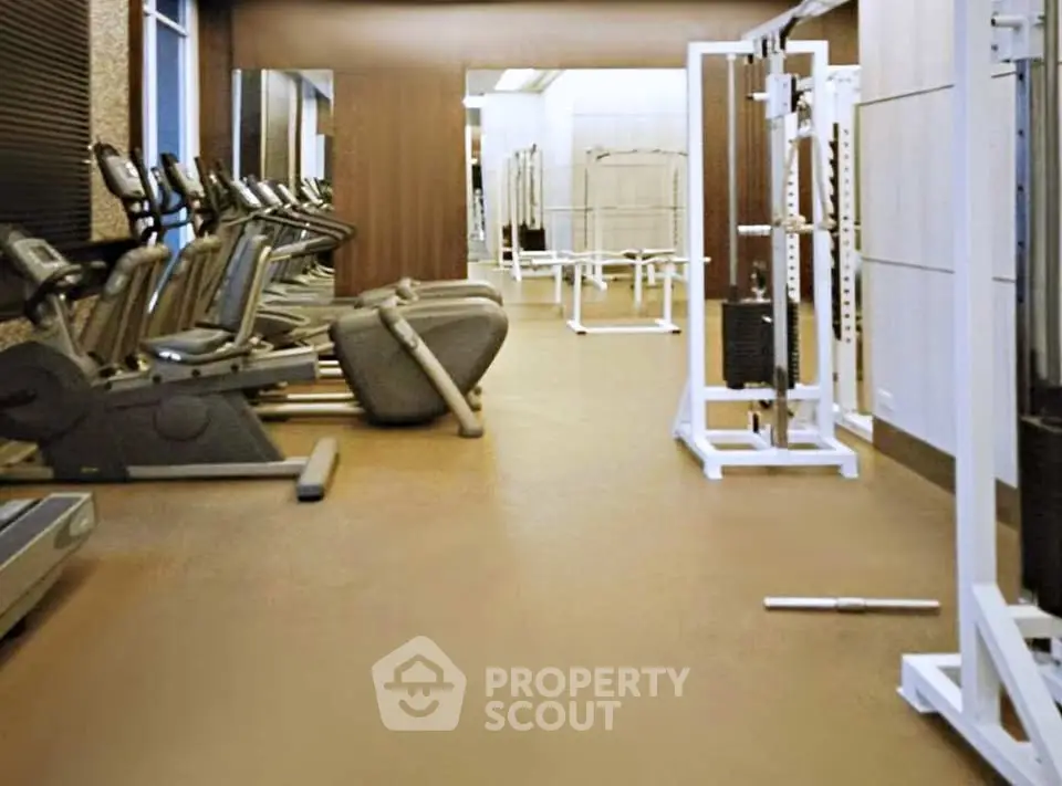 Modern gym with state-of-the-art fitness equipment in luxury residential building.