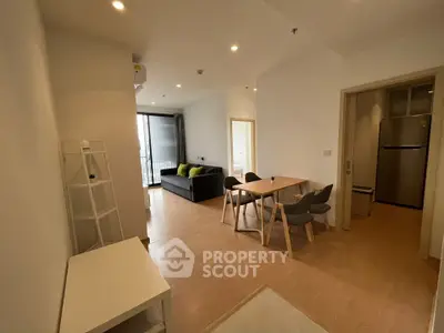 Modern living room with dining area and balcony access in a stylish apartment.