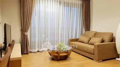 Elegant living room with large window, cozy sofa, and stylish coffee table in modern apartment.