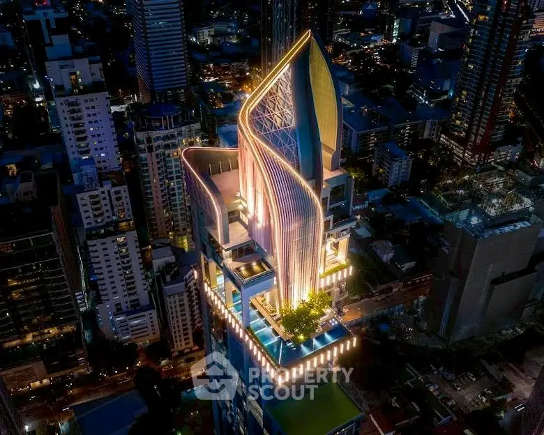 Stunning aerial view of a modern skyscraper with unique architectural design and vibrant city lights.