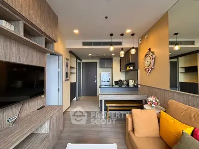 Modern living room with open kitchen, stylish decor, and cozy seating area in a contemporary apartment.