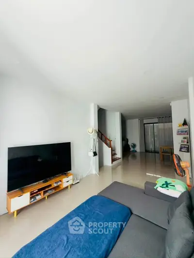 Spacious modern living room with sleek TV setup and cozy seating area, perfect for relaxation.