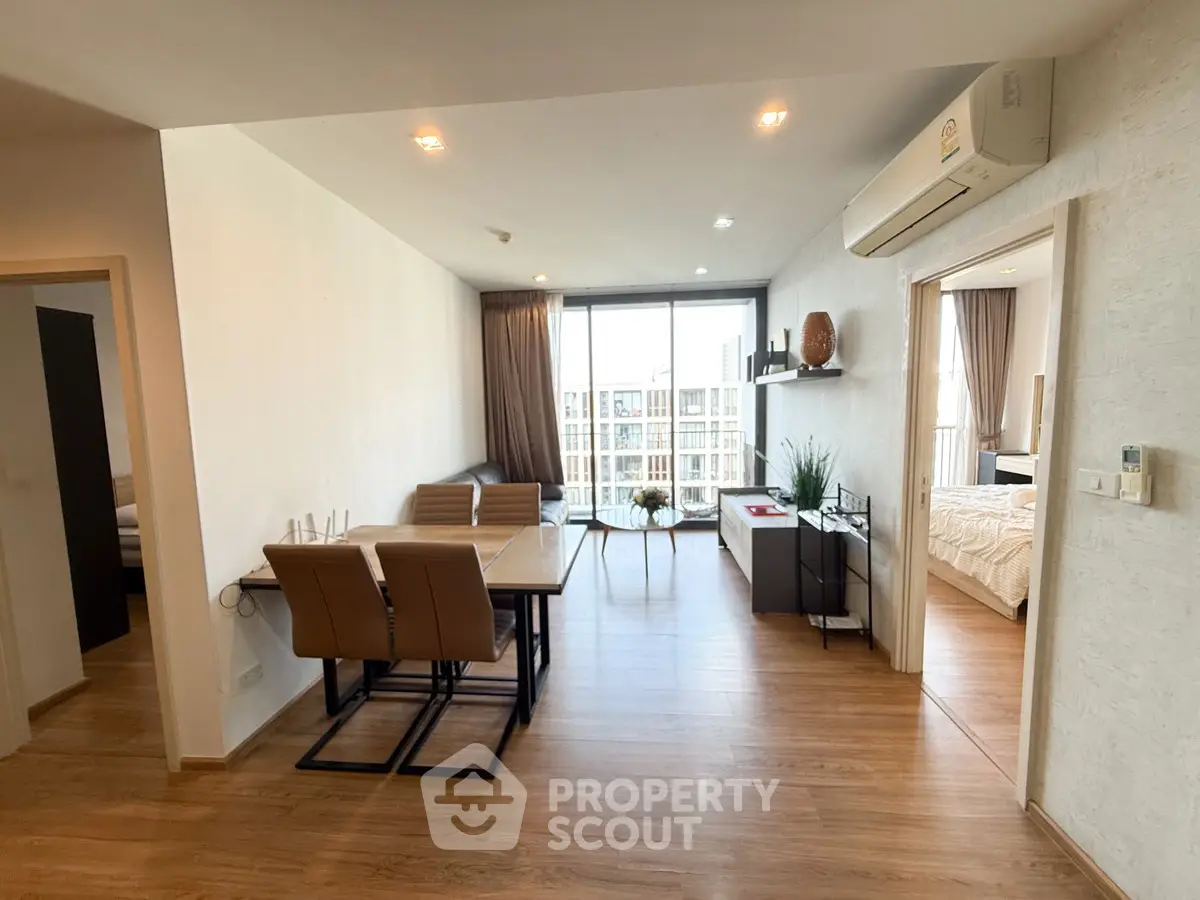 Spacious modern living room with dining area and balcony view