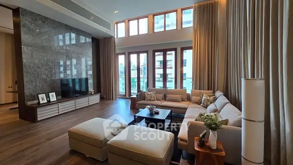 Luxurious living room with high ceilings and large windows offering stunning views.