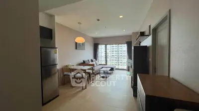 Modern living room with dining area and large window view in a stylish apartment.